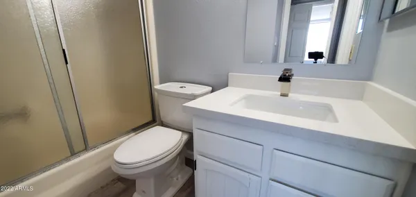 a bathroom with a sink a toilet and mirror