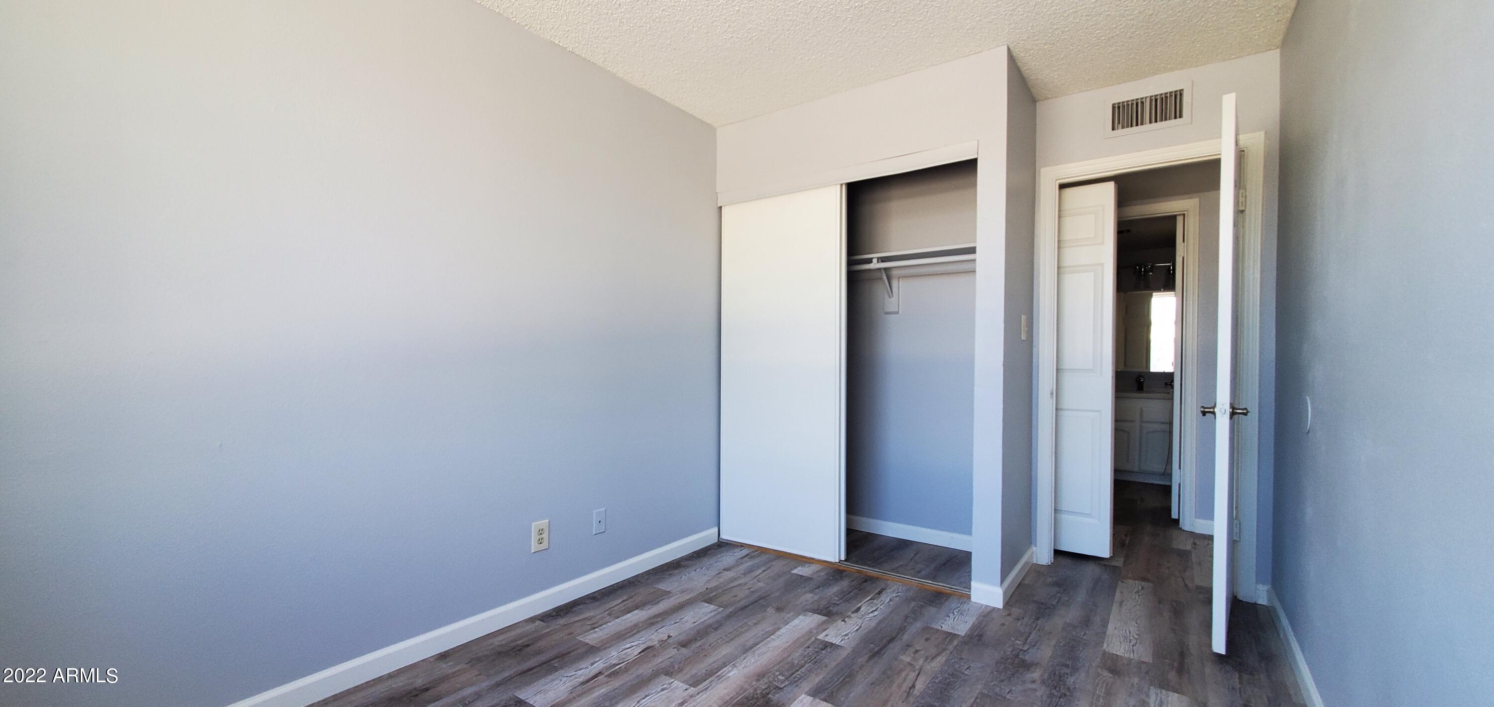 3411 North 12th Place, Unit 8 Phoenix, AZ 85014 - Photo 30 of 41 a view of an empty room with closet and wooden floor