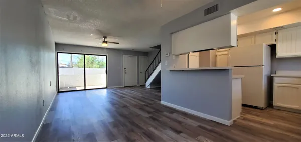 wooden floor in an empty room with a kitchen