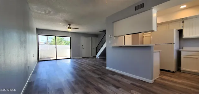 wooden floor in an empty room with a kitchen