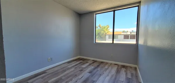 a view of empty room with wooden floor