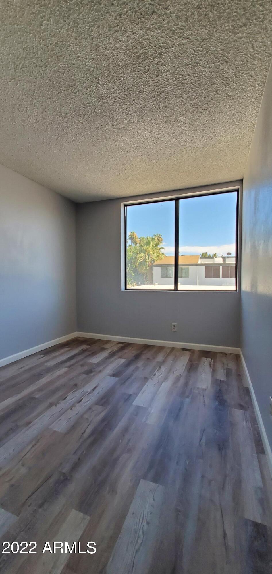 3411 North 12th Place, Unit 8 Phoenix, AZ 85014 - Photo 35 of 41 an empty room with wooden floor and windows
