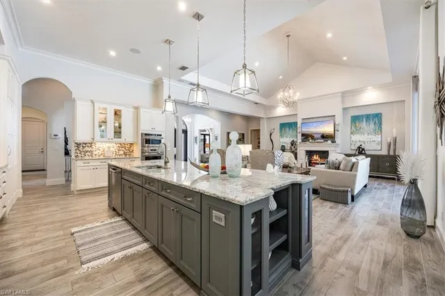 a large kitchen with stainless steel appliances kitchen island a large counter top space a sink stainless steel appliances and cabinets