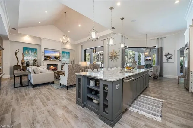 a large kitchen with stainless steel appliances a sink stove and cabinets