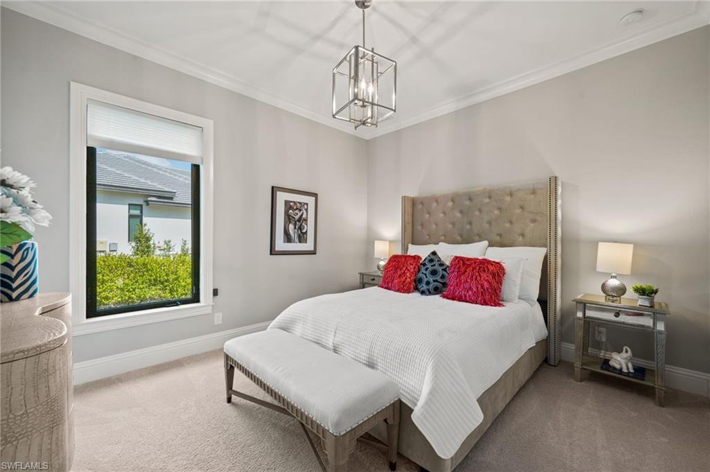 6363 Burnham Road Naples, FL 34119 - Photo 22 of 38 a bedroom with a bed and a chandelier