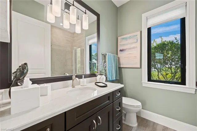 a bathroom with a double vanity sink toilet and a mirror