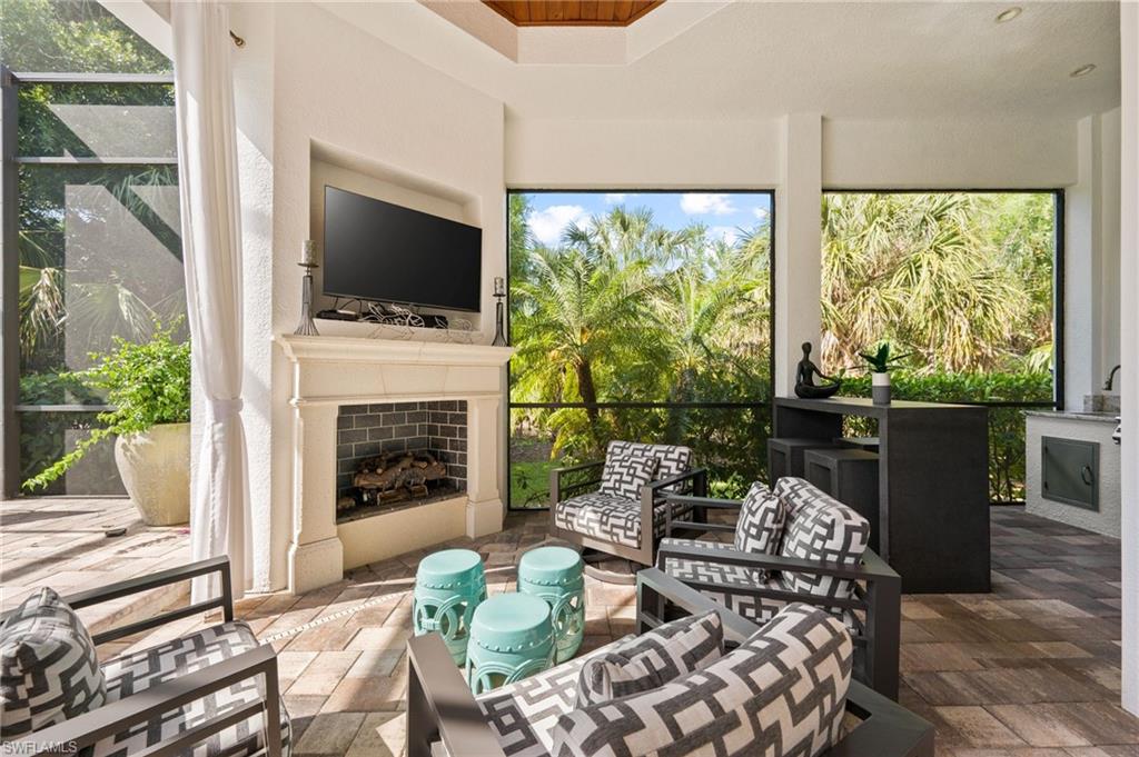 6363 Burnham Road Naples, FL 34119 - Photo 33 of 38 a living room with furniture a flat screen tv and a fireplace
