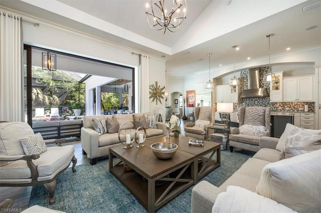 6363 Burnham Road Naples, FL 34119 - Photo 7 of 38 a living room with furniture a large window and a table