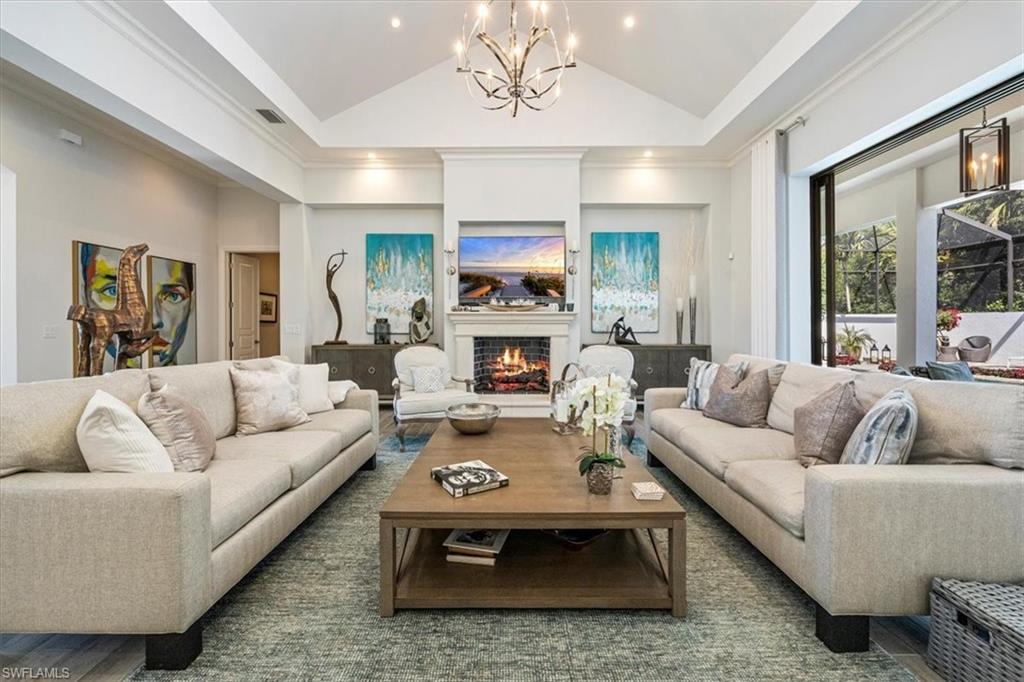 6363 Burnham Road Naples, FL 34119 - Photo 8 of 38 a living room with furniture fireplace and a large window