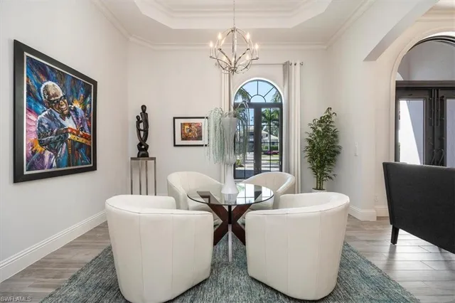 a view of a dining room with furniture a chandelier and wooden floor