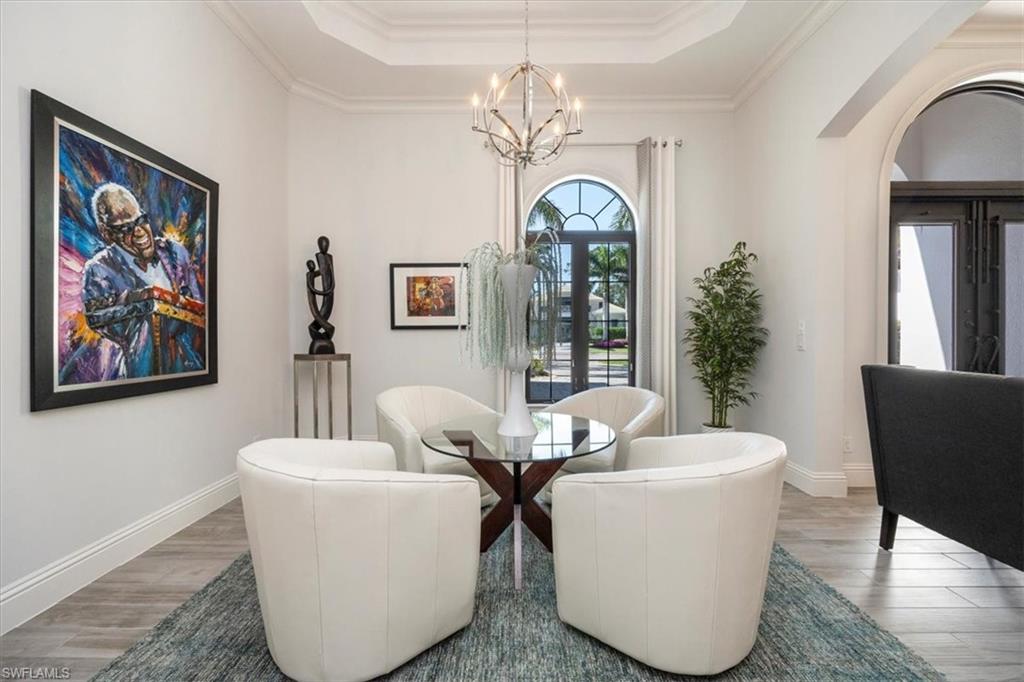 6363 Burnham Road Naples, FL 34119 - Photo 9 of 38 a view of a dining room with furniture a chandelier and wooden floor