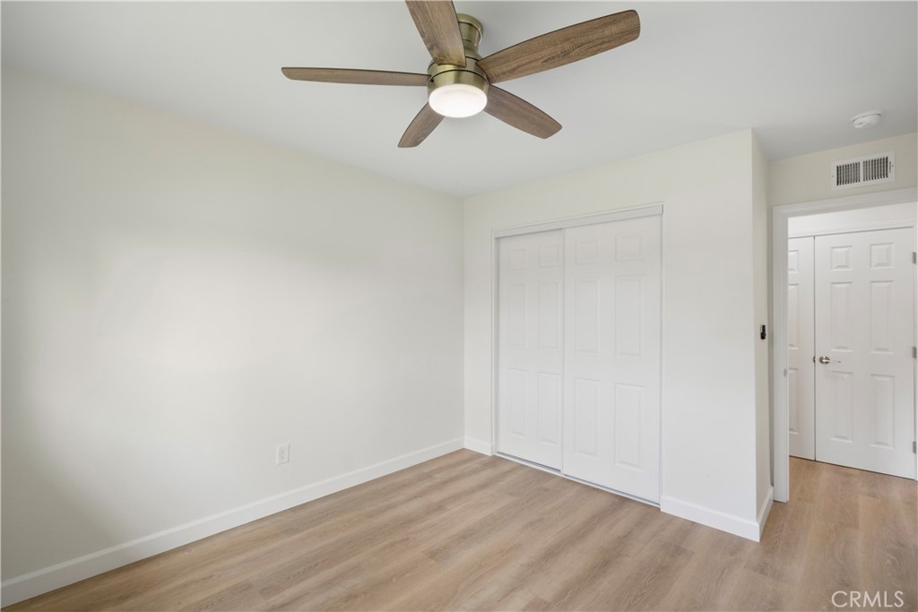 3670 Upper Terrace Drive Riverside, CA 92505 - Photo 16 of 30 an empty room with wooden floor ceiling fan and window