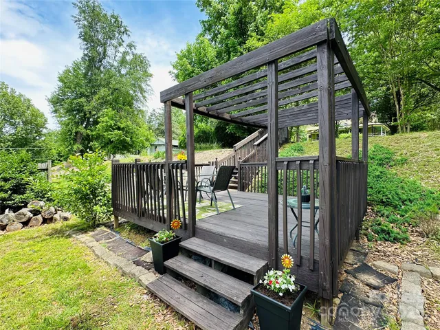 a view of backyard with wooden fence and a large tree