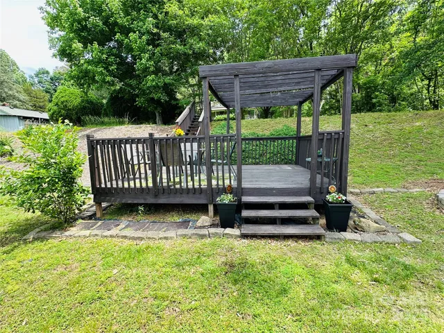a view of house with a deck and furniture