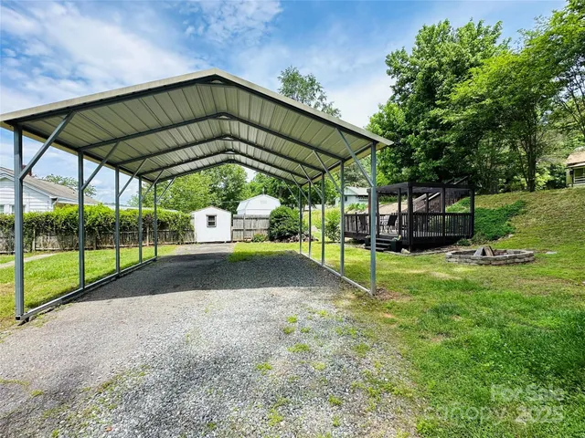 a view of a backyard with wooden fence and a bench