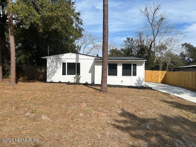 a front view of house with yard and trees in the background