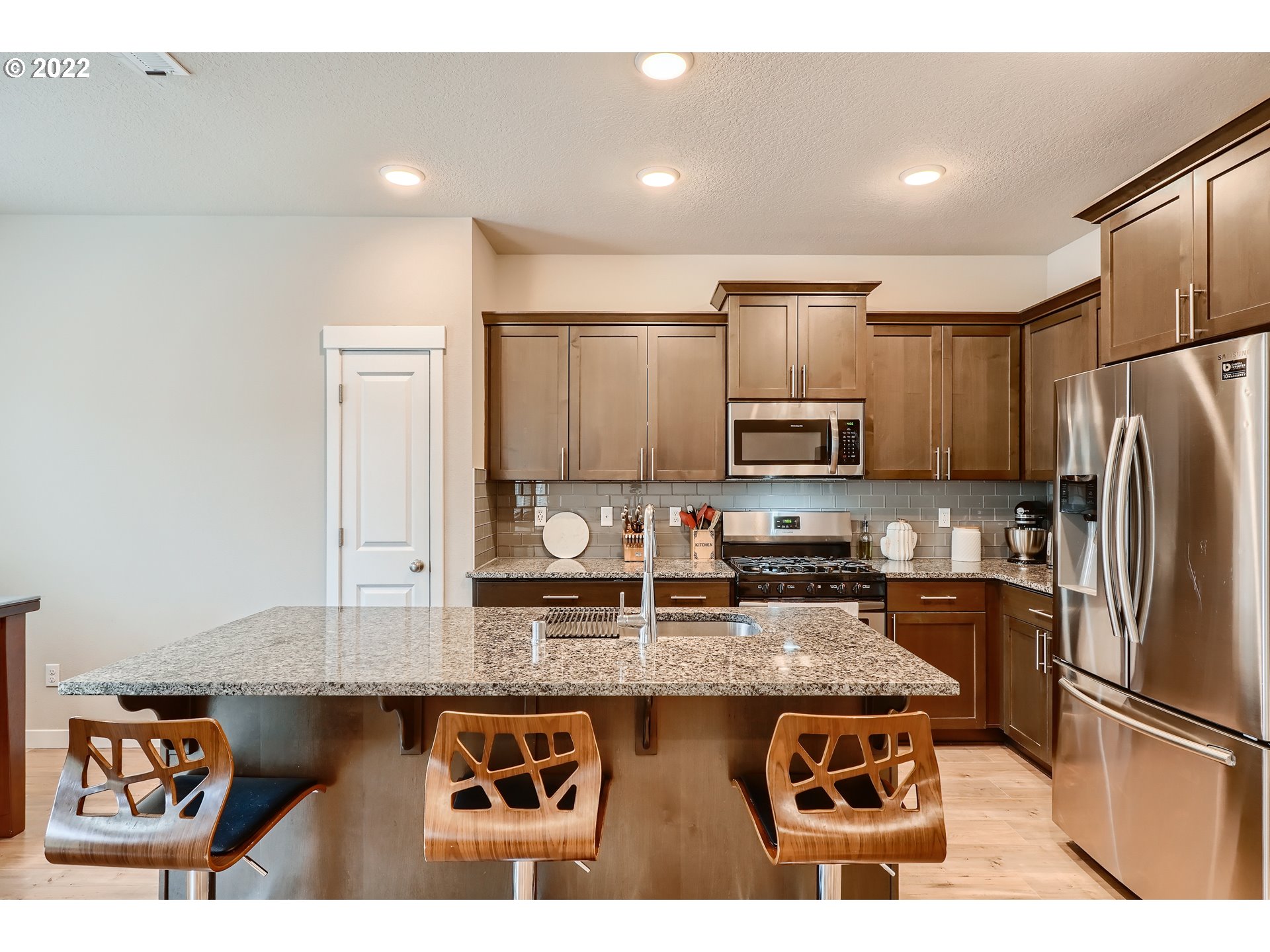 1416 Northeast 172nd Street Ridgefield, WA 98642 - Photo 11 of 28 a kitchen with stainless steel appliances granite countertop a refrigerator a stove and a sink