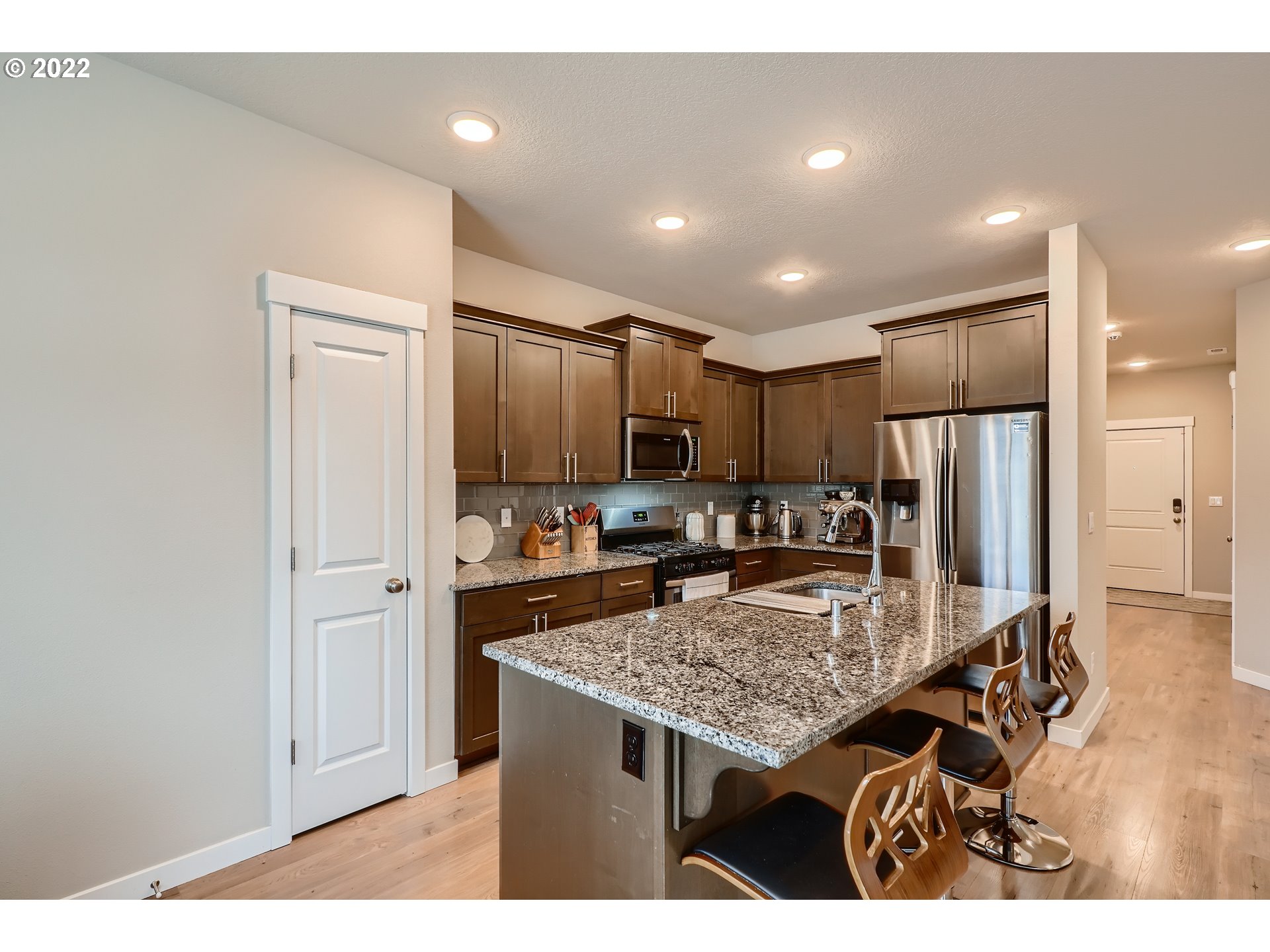 1416 Northeast 172nd Street Ridgefield, WA 98642 - Photo 10 of 28 a kitchen with kitchen island a refrigerator stove microwave and cabinets