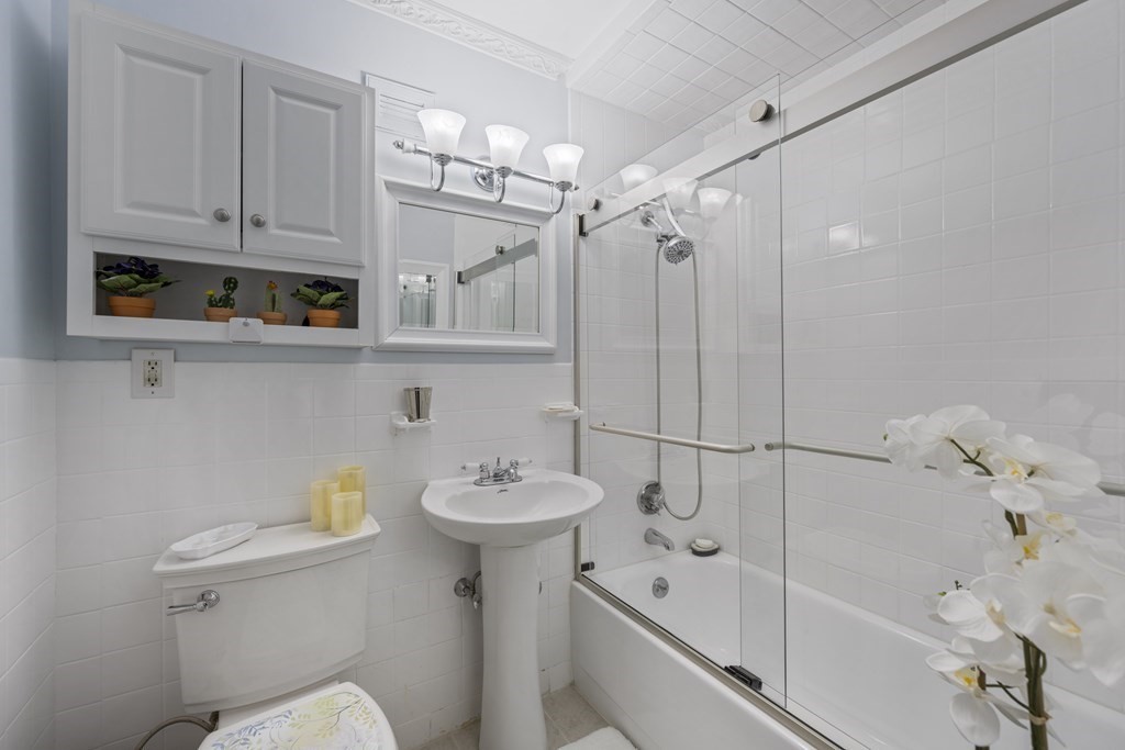 8 Juniper Street, Unit 22 Brookline, MA 02445 - Photo 5 of 11 a bathroom with a sink a toilet and shower
