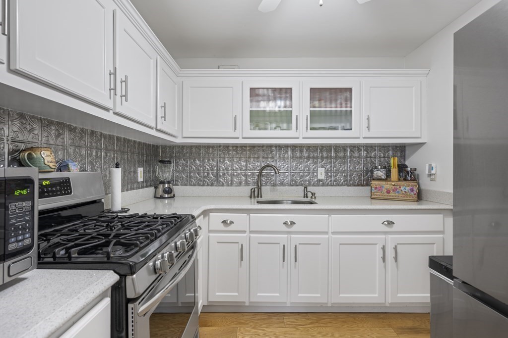 8 Juniper Street, Unit 22 Brookline, MA 02445 - Photo 6 of 11 a kitchen with white cabinets and appliances