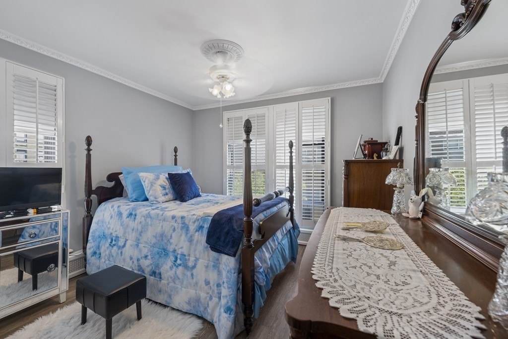8 Juniper Street, Unit 22 Brookline, MA 02445 - Photo 7 of 11 a bedroom with a bed and a flat screen tv