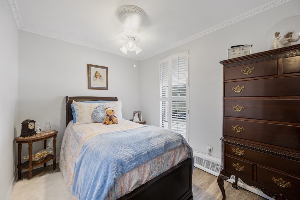 8 Juniper Street, Unit 22 Brookline, MA 02445 - Photo 8 of 11 a bedroom with a bed and a chandelier