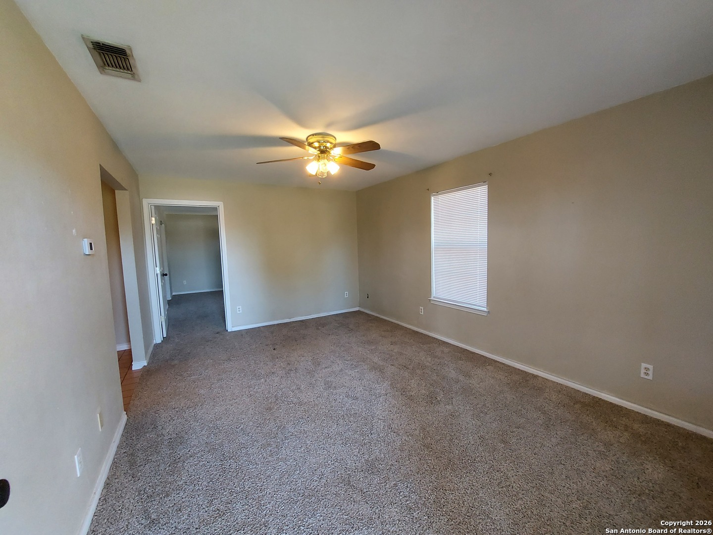 9510 Cross Rdg Lane San Antonio, TX 78263 - Photo 6 of 30 an empty room with a ceiling fan and a window