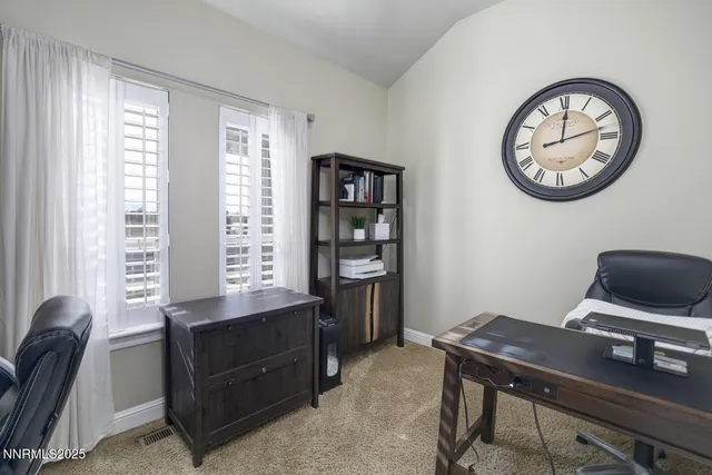 a view of a workspace with furniture and a window
