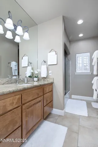 a bathroom with a granite countertop sink a mirror and a shower