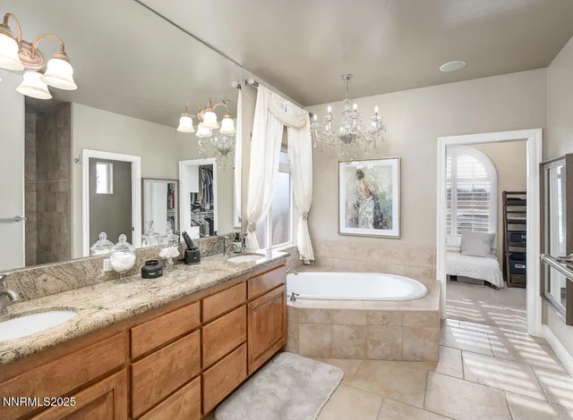 a spacious bathroom with a granite countertop sink mirror and a bathtub