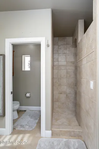 a bathroom with a granite countertop shower and a toilet