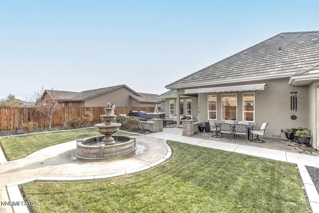 a view of a house with backyard sitting area and a garden