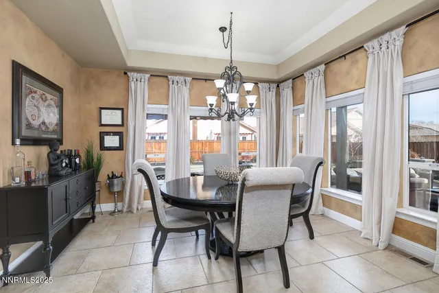 a dining room with furniture a chandelier and wooden floor