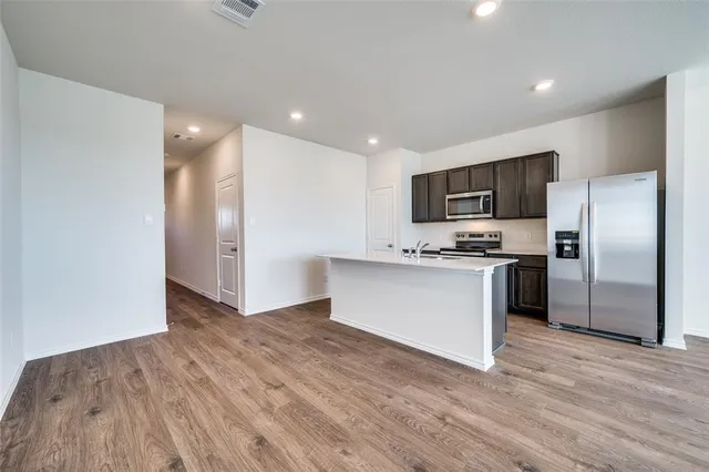 a kitchen with a refrigerator and a stove top oven