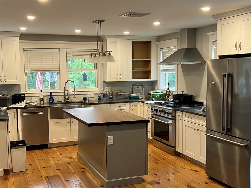 879 Long Pond Road Plymouth, MA 02360 - Photo 34 of 39 a kitchen with stainless steel appliances granite countertop a sink a stove a refrigerator and a refrigerator