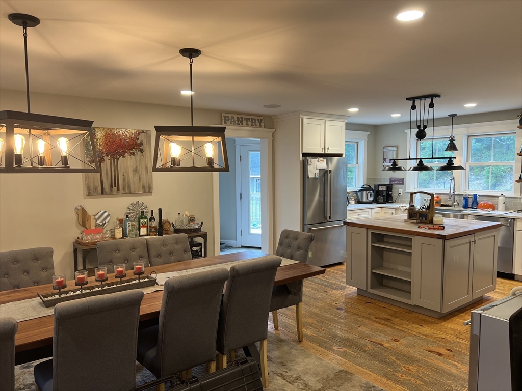 879 Long Pond Road Plymouth, MA 02360 - Photo 7 of 39 a kitchen with kitchen island granite countertop a stove top oven a sink dishwasher a dining table and chairs with wooden floor