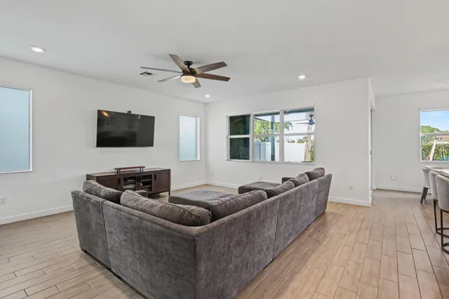 a kitchen with stainless steel appliances kitchen island granite countertop a wooden floor and white cabinets
