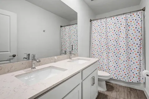 a bathroom with a granite countertop sink a toilet and a mirror