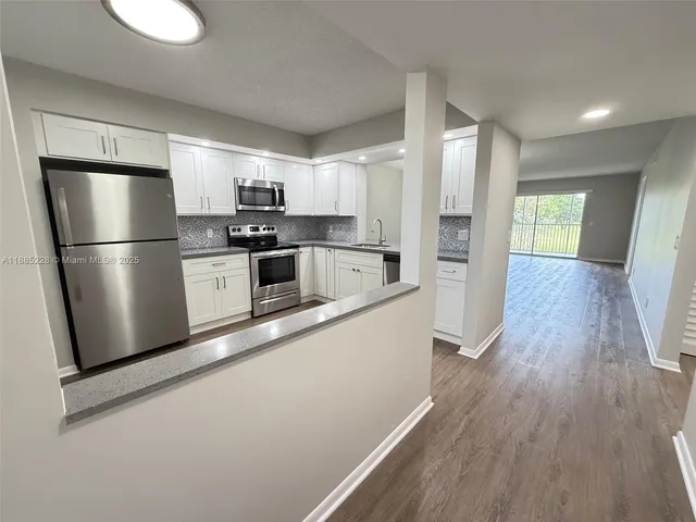 a kitchen with stainless steel appliances a refrigerator and a stove top oven