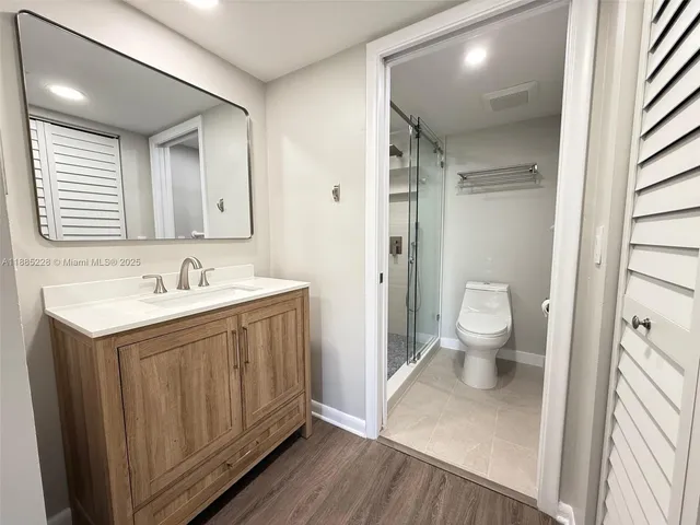 a bathroom with a sink a toilet and a large mirror