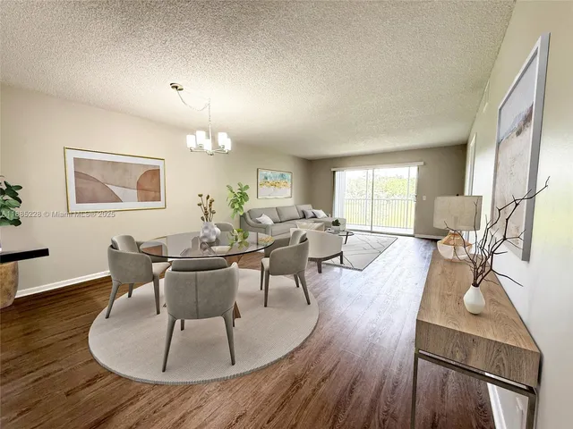 a living room with furniture a wooden floor and a large window