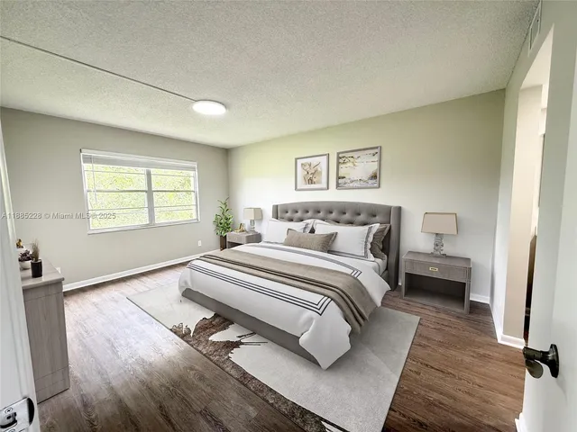 a spacious bedroom with a bed and wooden floor