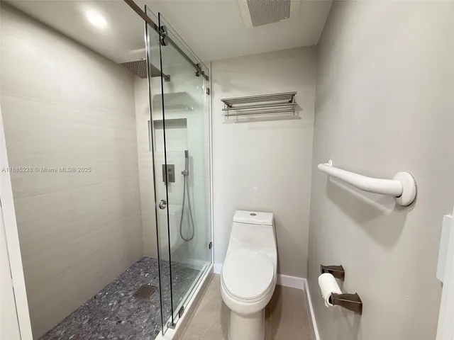 a white toilet sitting next to a shower