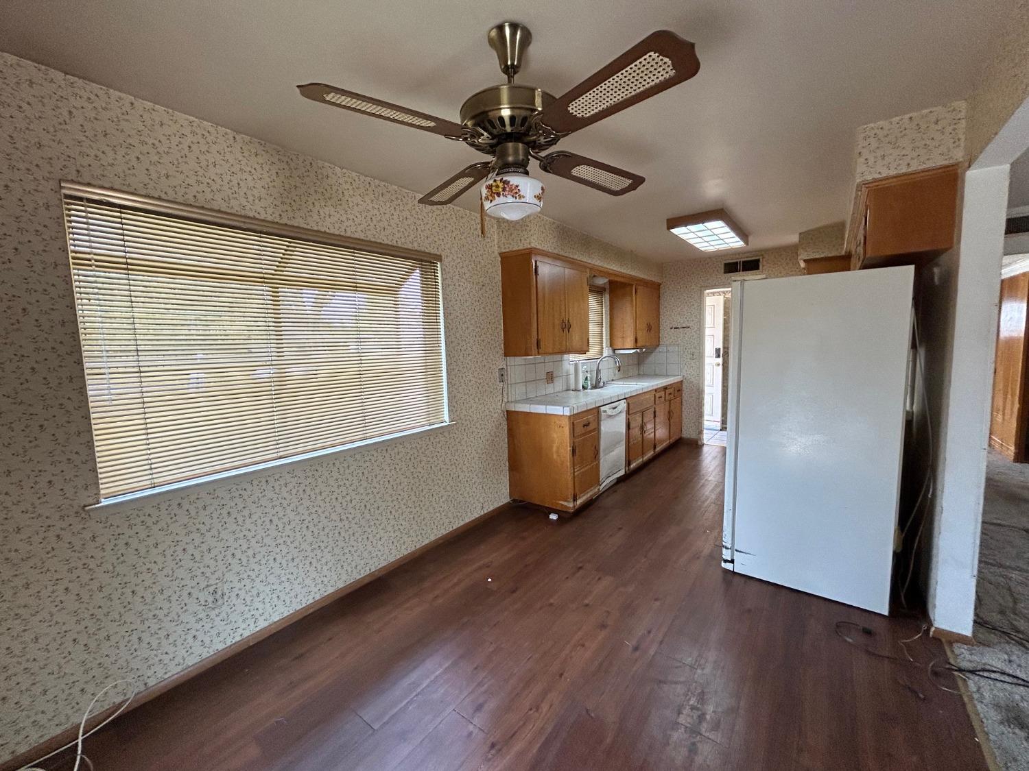 117 Berry Drive Madera, CA 93637 - Photo 4 of 16 a kitchen with stainless steel appliances a stove top oven a refrigerator cabinets and wooden floor