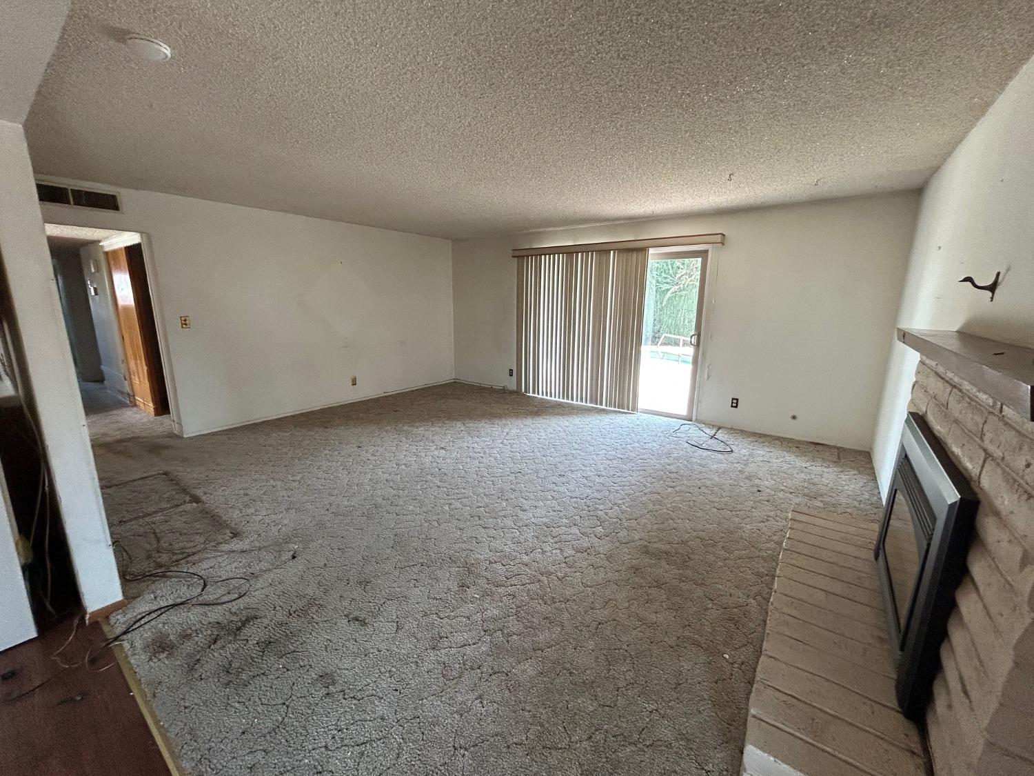 117 Berry Drive Madera, CA 93637 - Photo 5 of 16 a view of empty room with window and fireplace