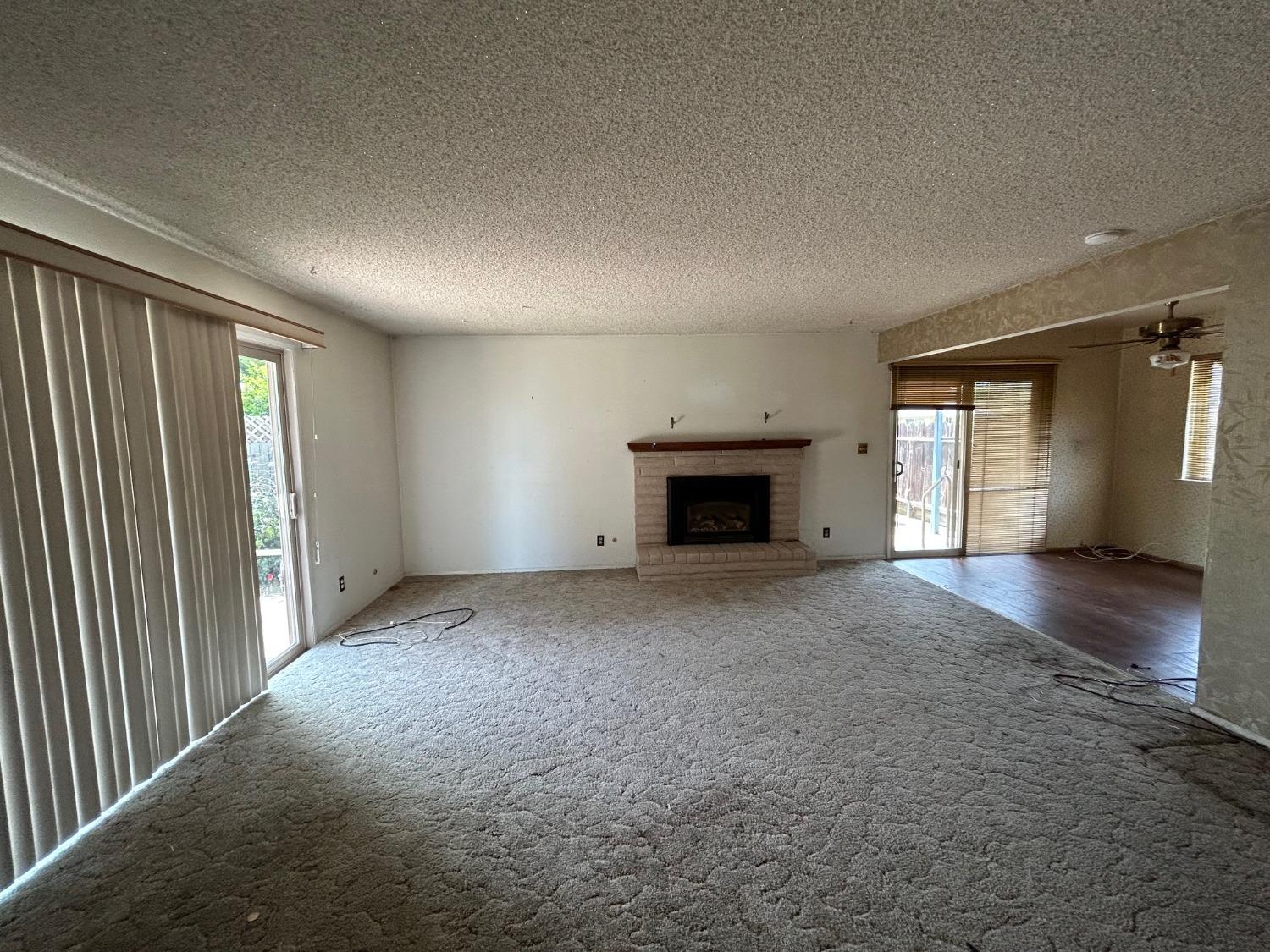 117 Berry Drive Madera, CA 93637 - Photo 6 of 16 an empty room with fireplace and windows