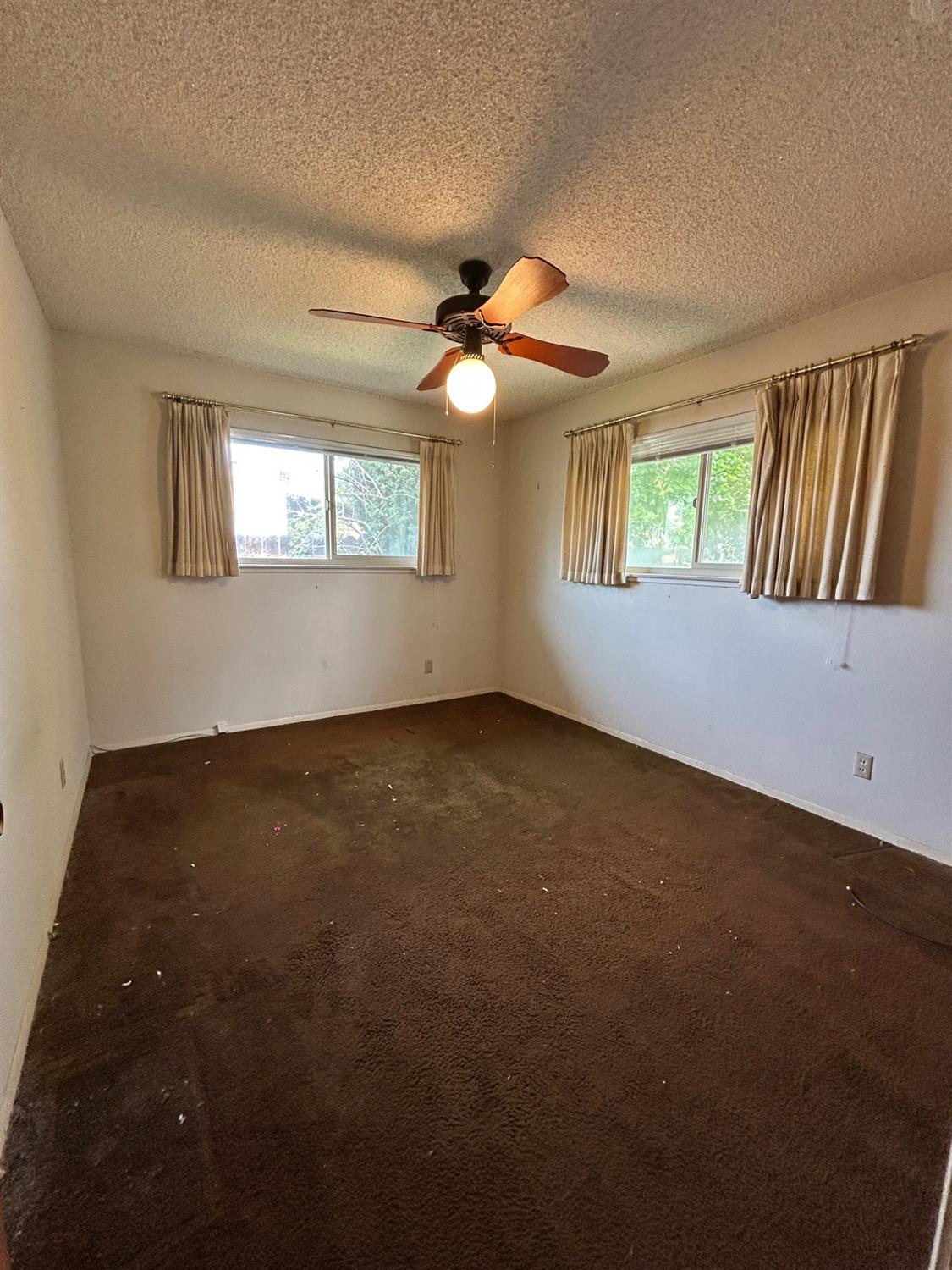 117 Berry Drive Madera, CA 93637 - Photo 10 of 16 an empty room with windows and fan