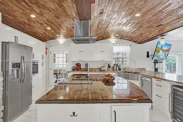 a kitchen with stainless steel appliances granite countertop a sink a stove and cabinets