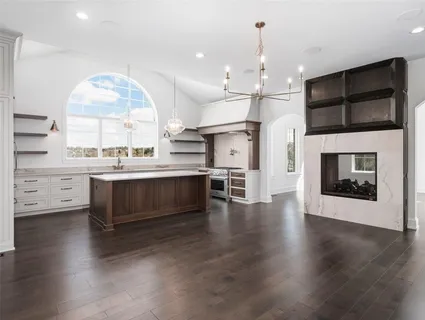 a kitchen with stainless steel appliances a stove top oven a sink and a fireplace