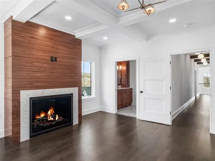 a view of an empty room with wooden floor fireplace and a window